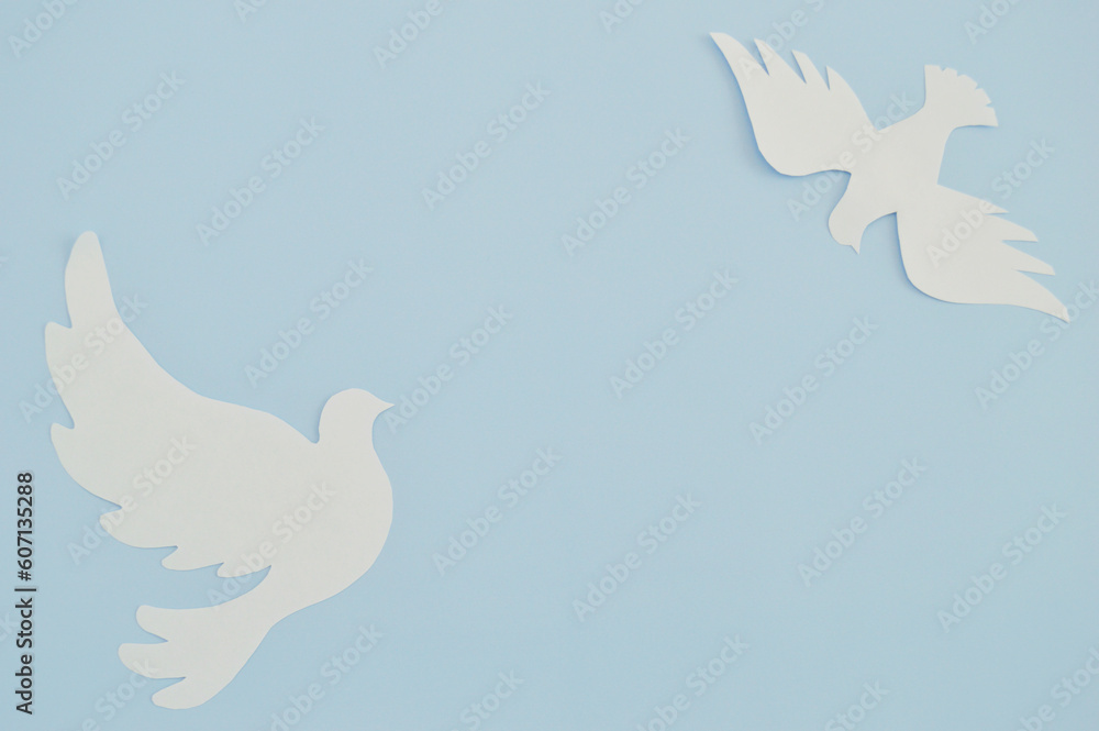 White paper origami bird on blue background. World Day of Peace. Day Against Humiliation. International Day Of Human Fraternity. International Day of Living Together in Peace White paper origami bird on blue background. World Day of Peace. Day Against Humiliation. International Day Of Human Fraternity. International Day of Living Together in Peace