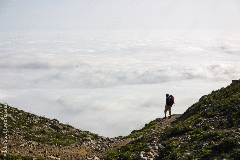 Caminante con mar de nubes en la montaña