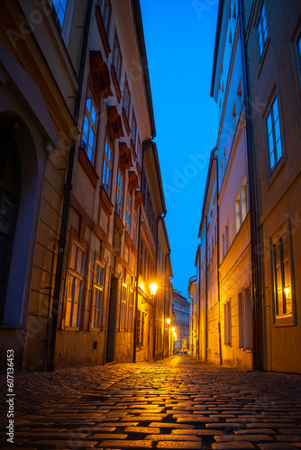 Romantic narrow street at Lesser town  Prague. Evening and street lamps on.
