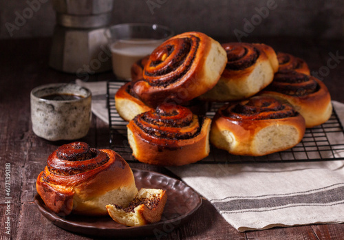 Obraz na płótnie Yeast dough cinnabons with poppy seeds, raisins and candied fruits, served with coffee. Rustic style. w salonie