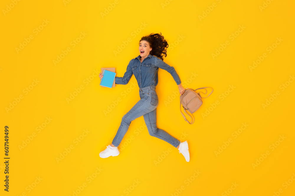 Lady Student With Backpack And Books Running Over Yellow Background