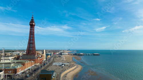 Aerial footage,of the famous Blackpool Tower and beach from the sky on a beautiful Summers day on one of Great Britains most popular holiday destinations, tourist attractions by the sea