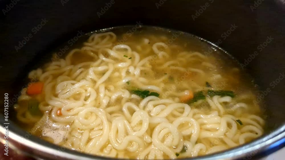 Pouring noodle soup with dipper