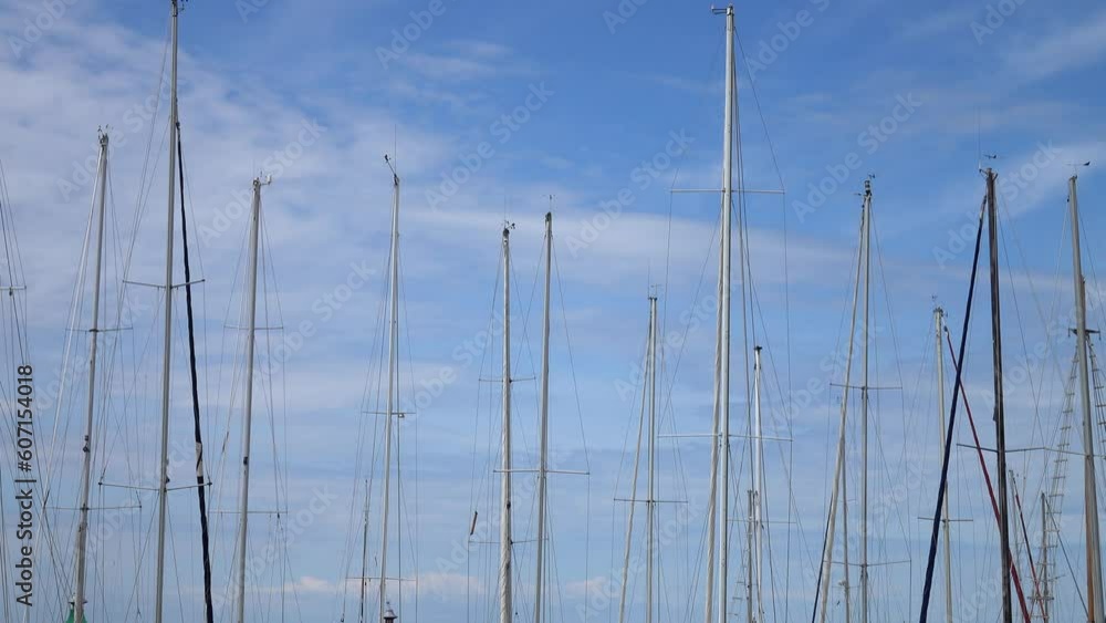 The masts of the yachts sway slowly against the sky and clouds, background The masts of the yachts sway slowly against the sky and clouds, background