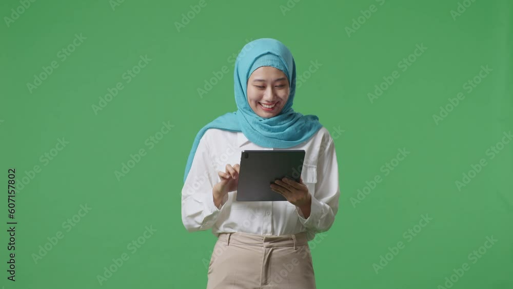 Asian Muslim Woman Smiling And Using Tablet While Standing In The Green Screen Background Studio
Asian Muslim Woman Smiling And Using Tablet While Standing In The Green Screen Background Studio