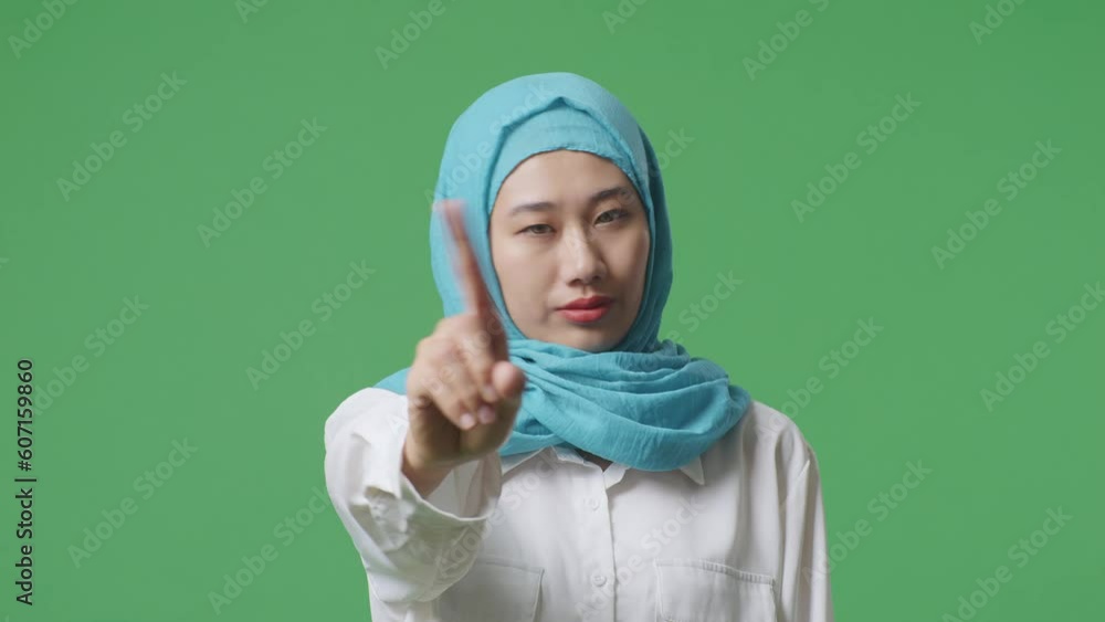 Close Up Of Asian Muslim Woman Disapproving With No Index Finger Sign While Standing In The Green Screen Background Studio
Close Up Of Asian Muslim Woman Disapproving With No Index Finger Sign While Standing In The Green Screen Background Studio