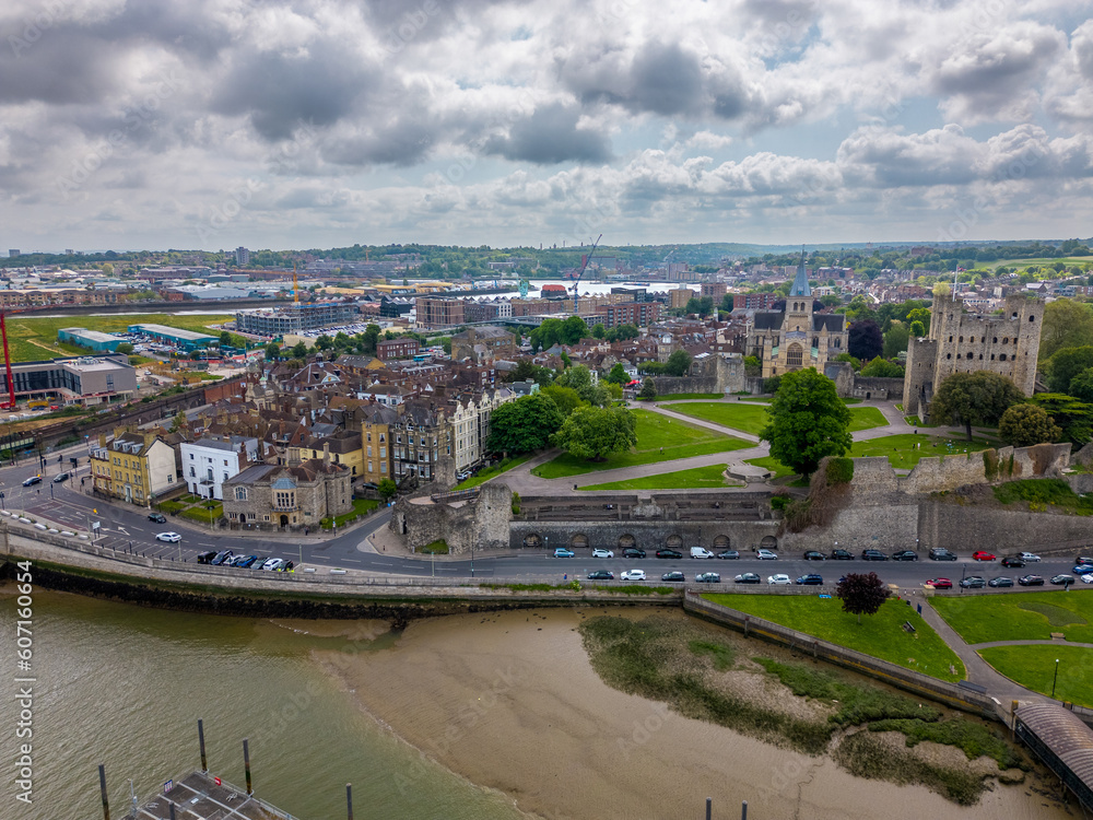 This aerial drone photo shows the city of Rochester in Kent, southern England. There is a beautiful old tower in the center surrounded by a park and an old church.