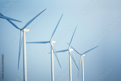 Close-up wind turbines against blue sky Green ecological power energy generation