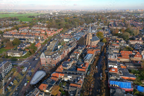 Aerial drone photo of the town center of Voorschoten in Zuid-Holland, the Netherlands. There is a church and a shopping street.  © robin