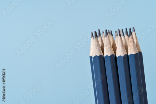 Bundle of blue Pencils on blue. Back to School or drawing and creativity concept. Office supply. Copy space. Side view close up