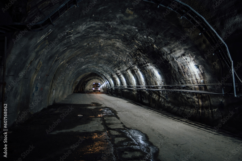 Naklejka premium Bus inside old underground road tunnel inside mountain