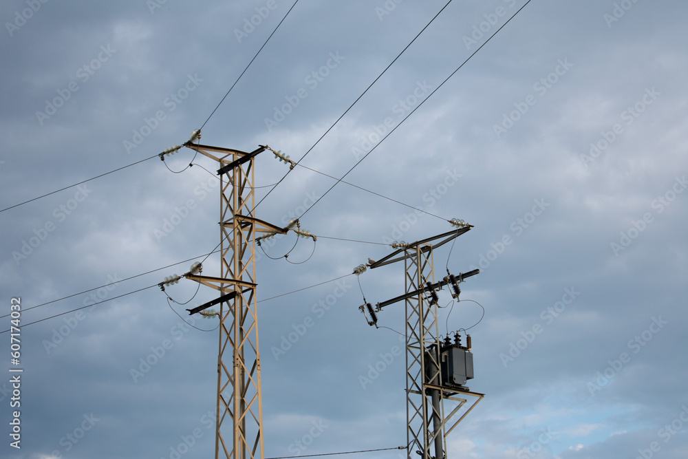 High-power electricity poles in the urban area connected to the smart grid. Power supply, power distribution, power transmission, high voltage concept photo. Cloudy sky. Malaga, Spain. High-power electricity poles in the urban area connected to the smart grid. Power supply, power distribution, power transmission, high voltage concept photo. Cloudy sky. Malaga, Spain.