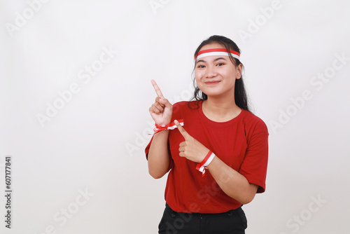 Young Indonesian girl celebrate indonesia independence day while pointing something on blank space