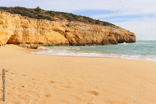 Beautiful sandy beach next to limestone cliff in the Atlantic Ocean on a sunny winter day along the Seven Hanging Valleys Trail in southern Portugal.