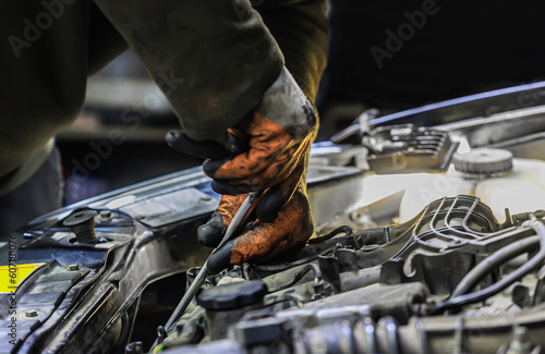 Hands of a car mechanic repairing a car engine