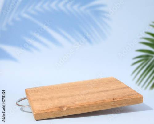 Wooden empty cutting board at an angle on a blue background  kitchen utensils