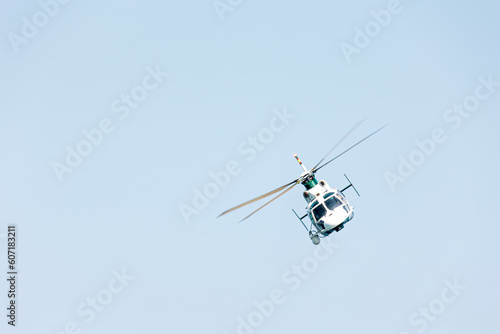 Front view of a Spanish military police helicopter doing control of the frontiers of the country over the sea on a summer day