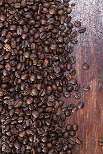 Natural background of roasted coffee beans on dark wood surface..