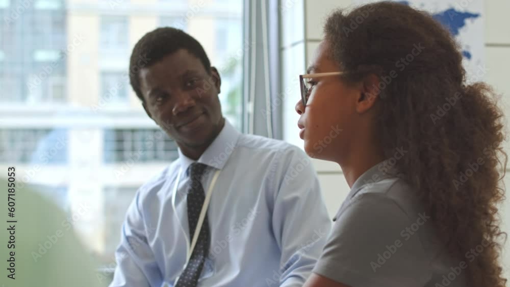 African American teenage schoolgirl sharing her mental problems with Black male school psychologist in his office African American teenage schoolgirl sharing her mental problems with Black male school psychologist in his office