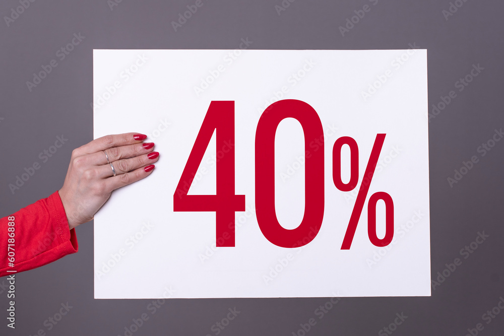 Female hand holding a 40% poster. Studio shot. Commercial concept. Female hand holding a 40% poster. Studio shot. Commercial concept.