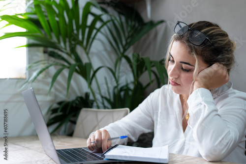 Bored caucasian young high school student tired of learning doing homework reading book, blonde teenager girl studying preparing for exam test, literature research, employee working concept. photo