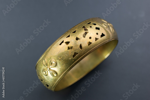 Huge old gold bangle bracelet, unique vintage jewelry background, bold jewelry concept, promotional photo for an online jewellery store