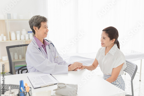 asian female doctor holding hand of patient in mental health clinic, patient have a problem health in hospital, hand in hand, healthcare promotion