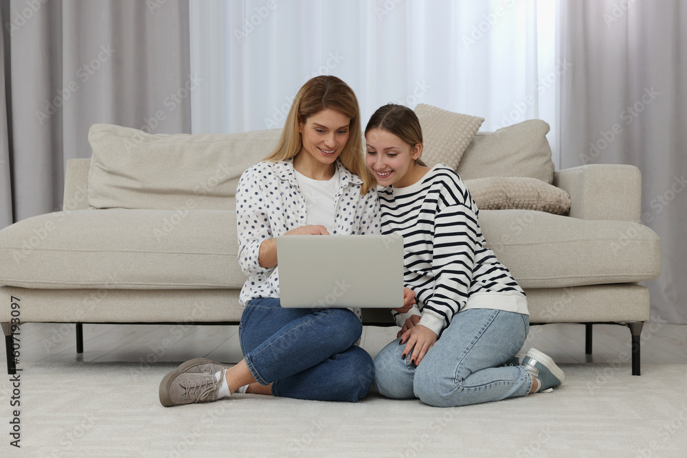 Happy mother and her teenage daughter with laptop on floor at home Happy mother and her teenage daughter with laptop on floor at home
