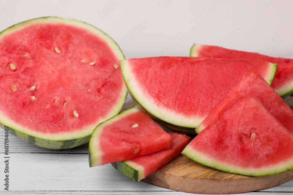 Juicy ripe cut watermelons on white table, closeup Juicy ripe cut watermelons on white table, closeup