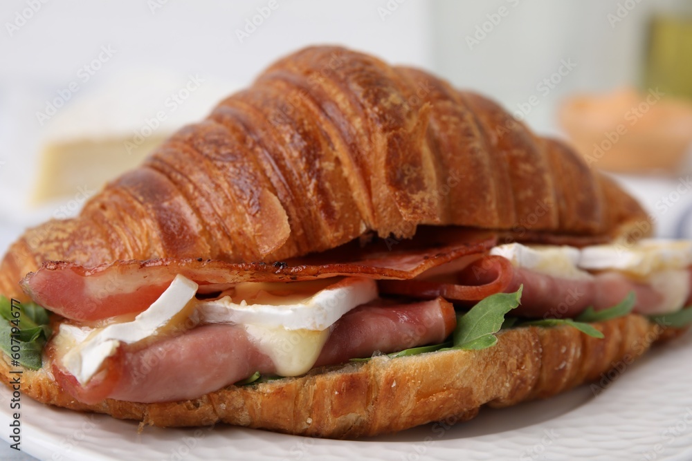 Tasty croissant with brie cheese, ham and bacon on plate, closeup Tasty croissant with brie cheese, ham and bacon on plate, closeup