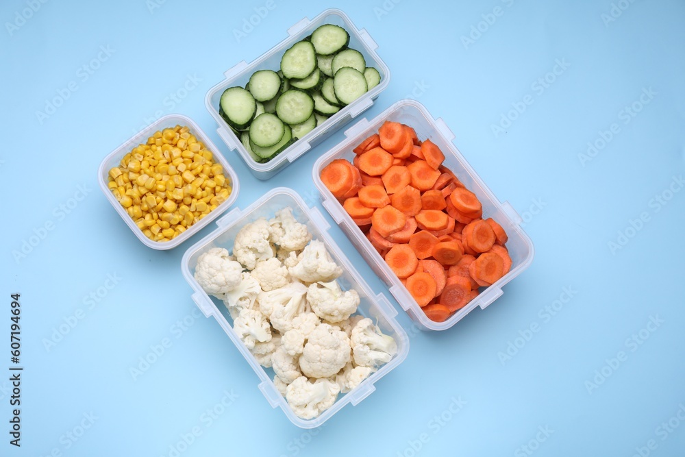 Plastic containers with different fresh products on light blue background, flat lay Plastic containers with different fresh products on light blue background, flat lay