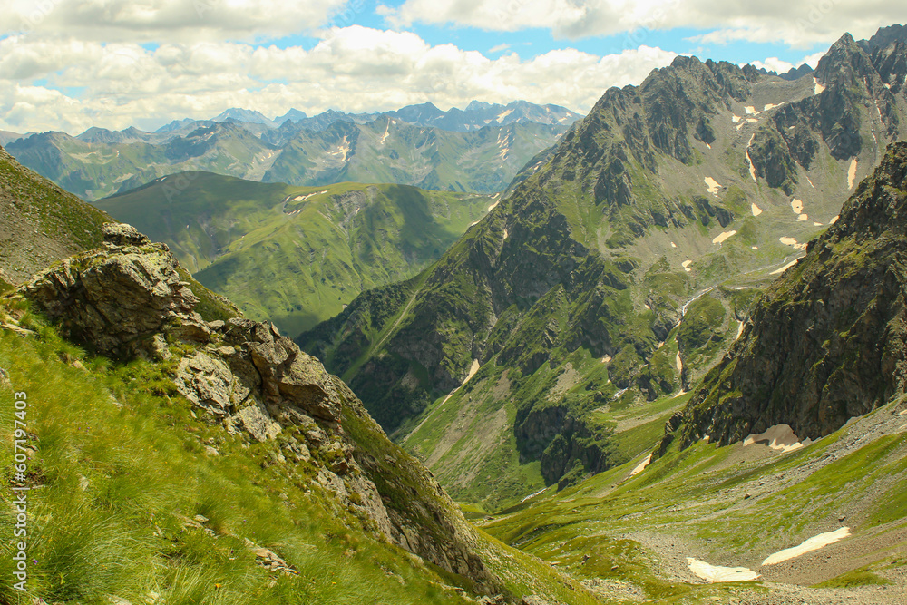 Fototapeta premium Panoramic landscape view, snow covered mountain peaks on mountain range. Hills and mountains covered with green pine forest, Arkhyz villadge, Caucasus mountains, Russia