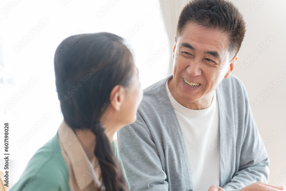 リビングにいる笑顔で話す高齢者夫婦 リビングにいる笑顔で話す高齢者夫婦