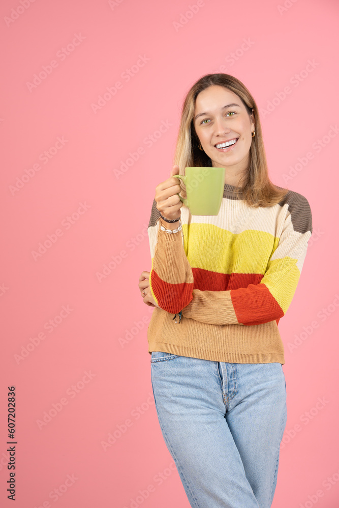 Young woman holding a cup of coffee and looking at the camera Young woman holding a cup of coffee and looking at the camera
