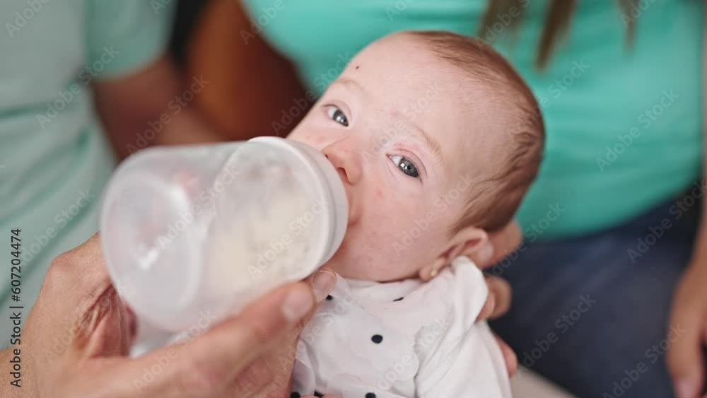Caucasian baby girl drinking milk from feeding bottle Caucasian baby girl drinking milk from feeding bottle