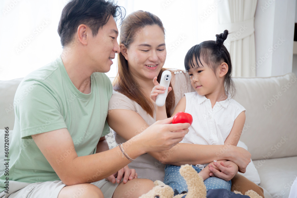 Happy family with daughter play doctor or nurse checkup and examining fever with father on sofa in living room at home, dream child, kid with imagination and playful, lifestyles and medical concept. Happy family with daughter play doctor or nurse checkup and examining fever with father on sofa in living room at home, dream child, kid with imagination and playful, lifestyles and medical concept.