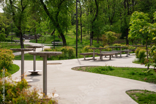 Fototapeta Naklejka Na Ścianę i Meble -  Wooden tables and benches in the summer park.