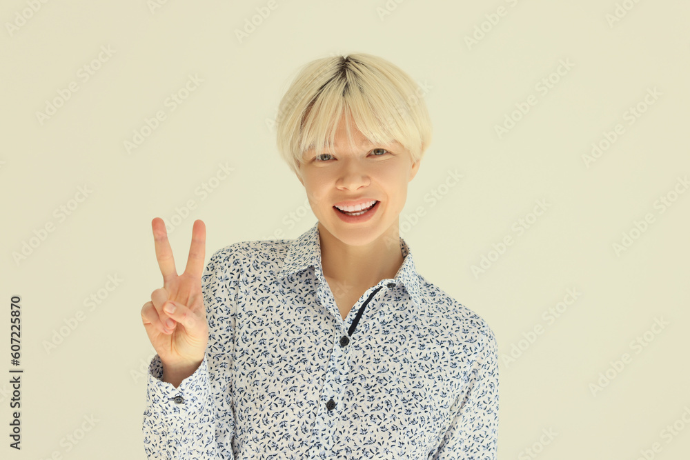 Positive blonde woman shows V sign of victory with fingers Positive blonde woman shows V sign of victory with fingers