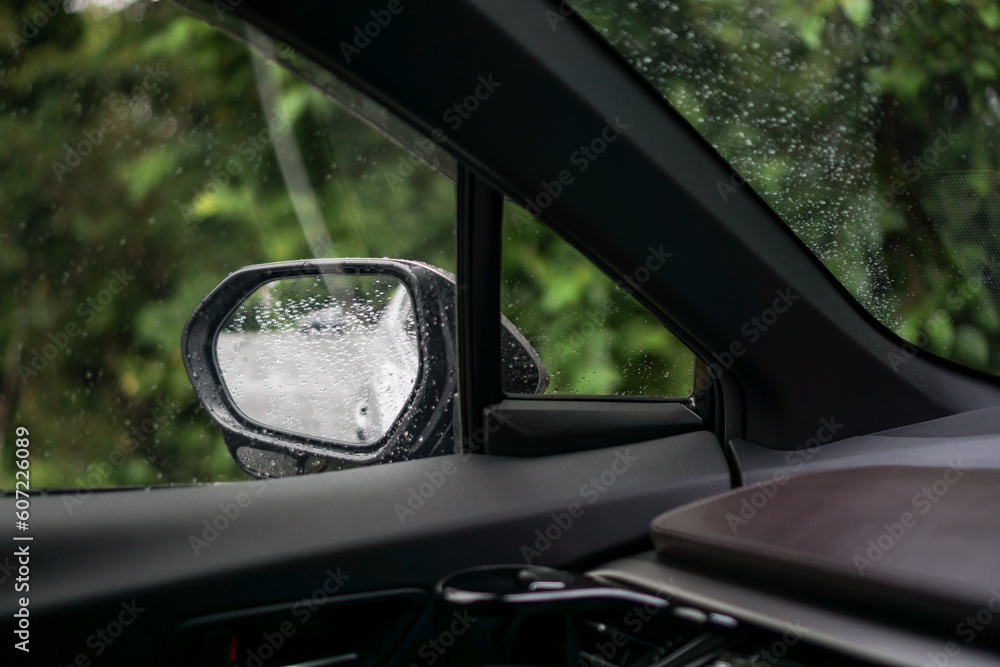 Obraz premium 雨の日の水滴のついた車のサイドミラー