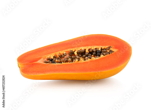 half of ripe papaya fruit with seeds on white background.