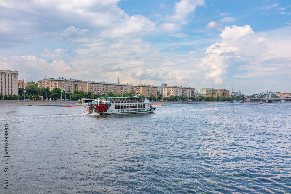 Naklejka premium Cruise ship sails on the Moscow river in Moscow city center, popular place for walking.