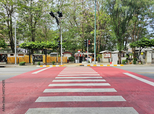 Crosswalk on the road, Pedestrian crossing with red and white stripes without people waiting for the green light. Bangkok, Thailand, May 19, 2023.