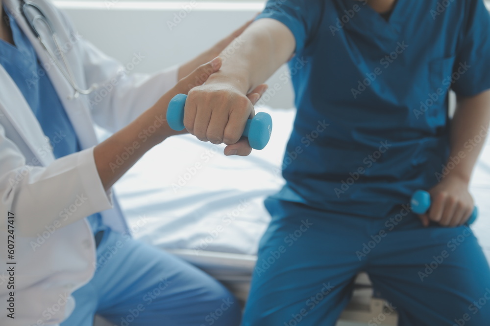 Doctor or Physiotherapist working examining treating injured arm of athlete male patient, stretching and exercise, Doing the Rehabilitation therapy pain in clinic. Doctor or Physiotherapist working examining treating injured arm of athlete male patient, stretching and exercise, Doing the Rehabilitation therapy pain in clinic.