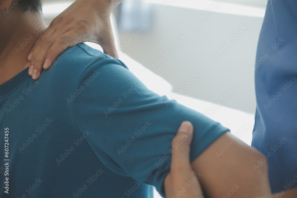 Doctor or Physiotherapist working examining treating injured arm of athlete male patient, stretching and exercise, Doing the Rehabilitation therapy pain in clinic. Doctor or Physiotherapist working examining treating injured arm of athlete male patient, stretching and exercise, Doing the Rehabilitation therapy pain in clinic.