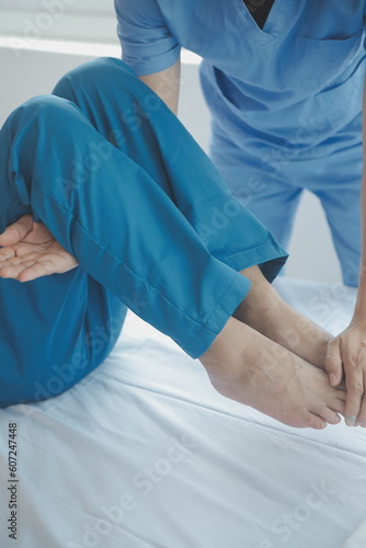 Doctor or Physiotherapist working examining treating injured arm of athlete male patient  stretching and exercise  Doing the Rehabilitation therapy pain in clinic.