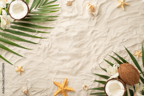 Dive into the summer season! Top view of seashells, starfish, palm leaves, alstroemeria flowers and a fresh coconut on a sandy background. Empty space for text or promotional content