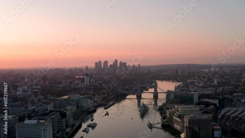 Slow aerial shot towards Canary wharf over the thames from central London at dawn photo