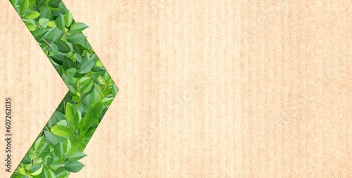 Photos Green leaves and arrow symbol on recycled cardboard texture