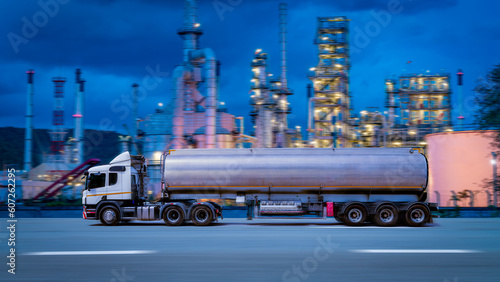 Fuel truck curry on highway for transport fuel to petrochemical oil with night light oil refinery background.