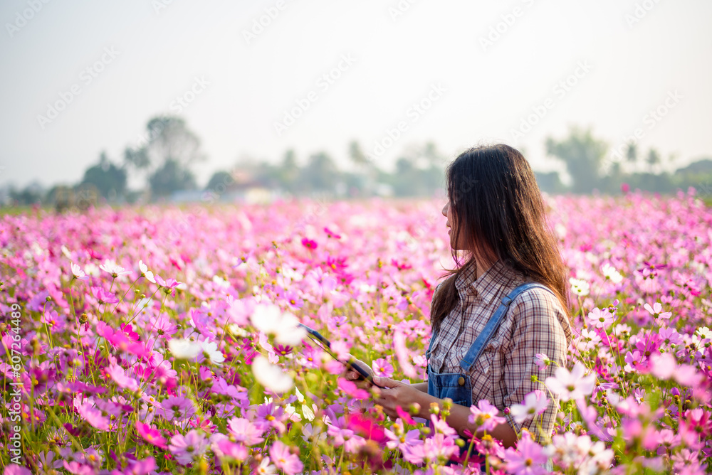 Happy woman farmer owner holding tablet at flower farm for modern farming, technology, agriculture, flower business idea concept. Happy woman farmer owner holding tablet at flower farm for modern farming, technology, agriculture, flower business idea concept.